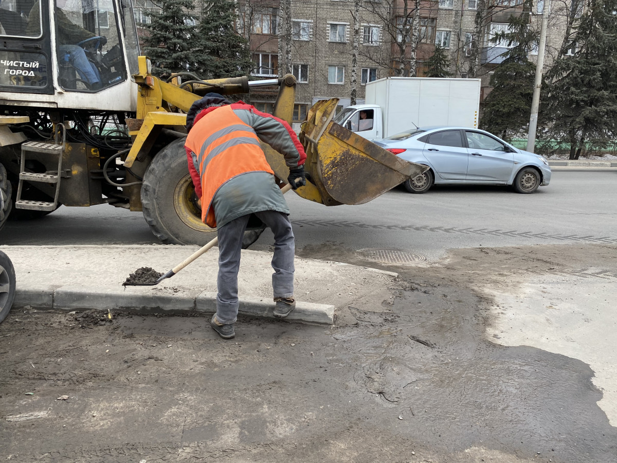 На улице Гвардейцев, Рябцева и Бурнаковском проезде коммунальщики Московского района расчищают прибордюрные полосы